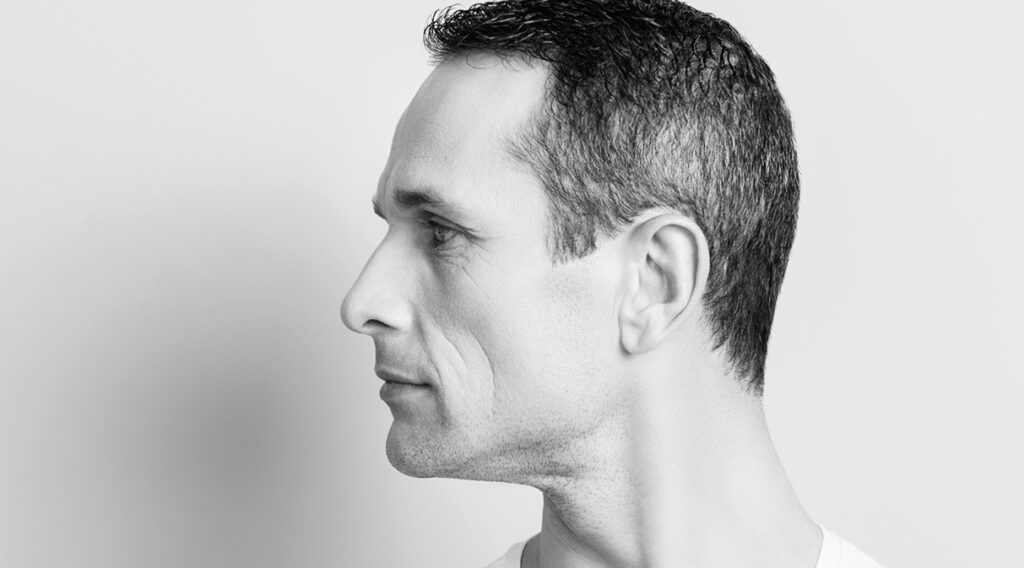 Portrait With Copy Space, Empty Place For Product, Advertisement Of Attractive, Stylish Man With Turned Profile Face To The Side, Having Perfect Ideal Oiled, Dry Skin, Isolated On Grey Background